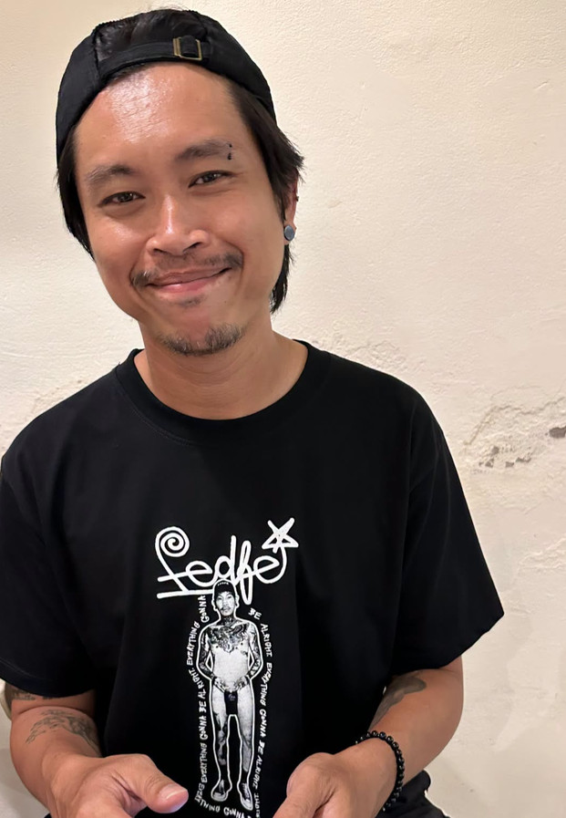 ต้า เฟ็ดเฟ่ ยิ้มรับกล้องในเสื้อยืดโลโก้ FEDFE