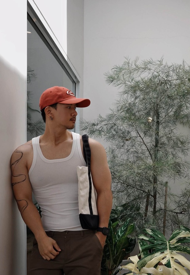 อามเหม่อ สวมหมวกแก๊ปแดงกับเสื้อกล้ามขาวกลางแจ้ง