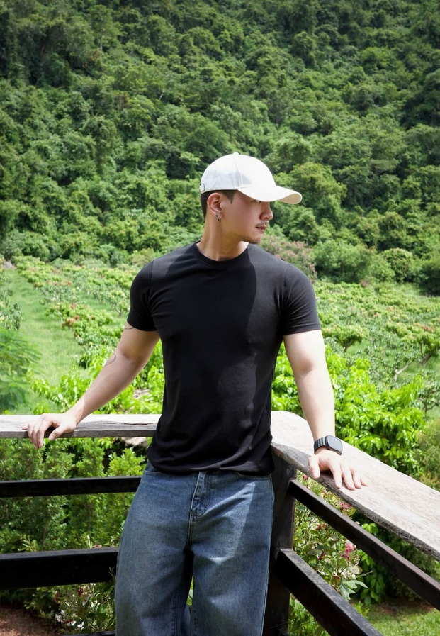 อามเหม่อ ใส่หมวกขาวกับเสื้อยืดดำถ่ายกลางวิวภูเขา