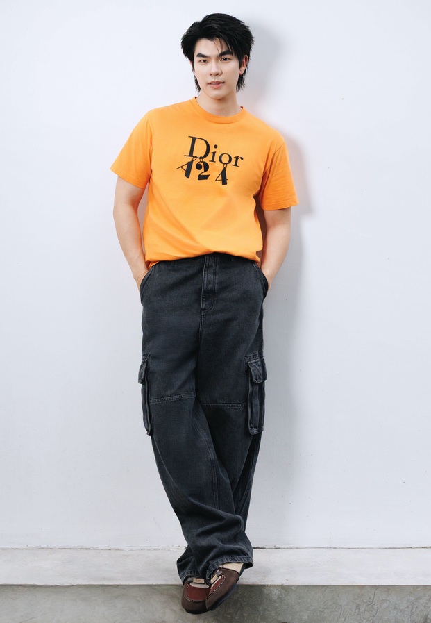 มาย ภาคภูมิ ในเสื้อยืดสีส้มกับกางเกงคาร์โก้สีดำ