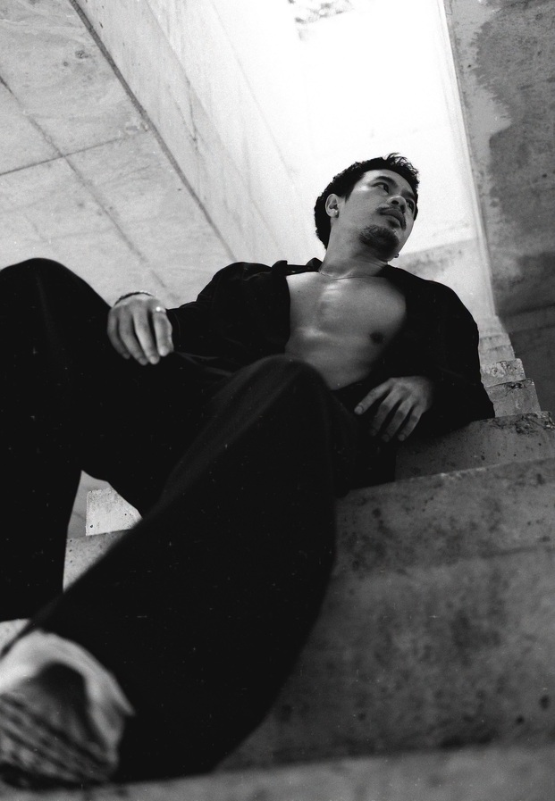 Suriya Danongkhai เอนตัวบนบันไดปูนในภาพโทนขาวดำ